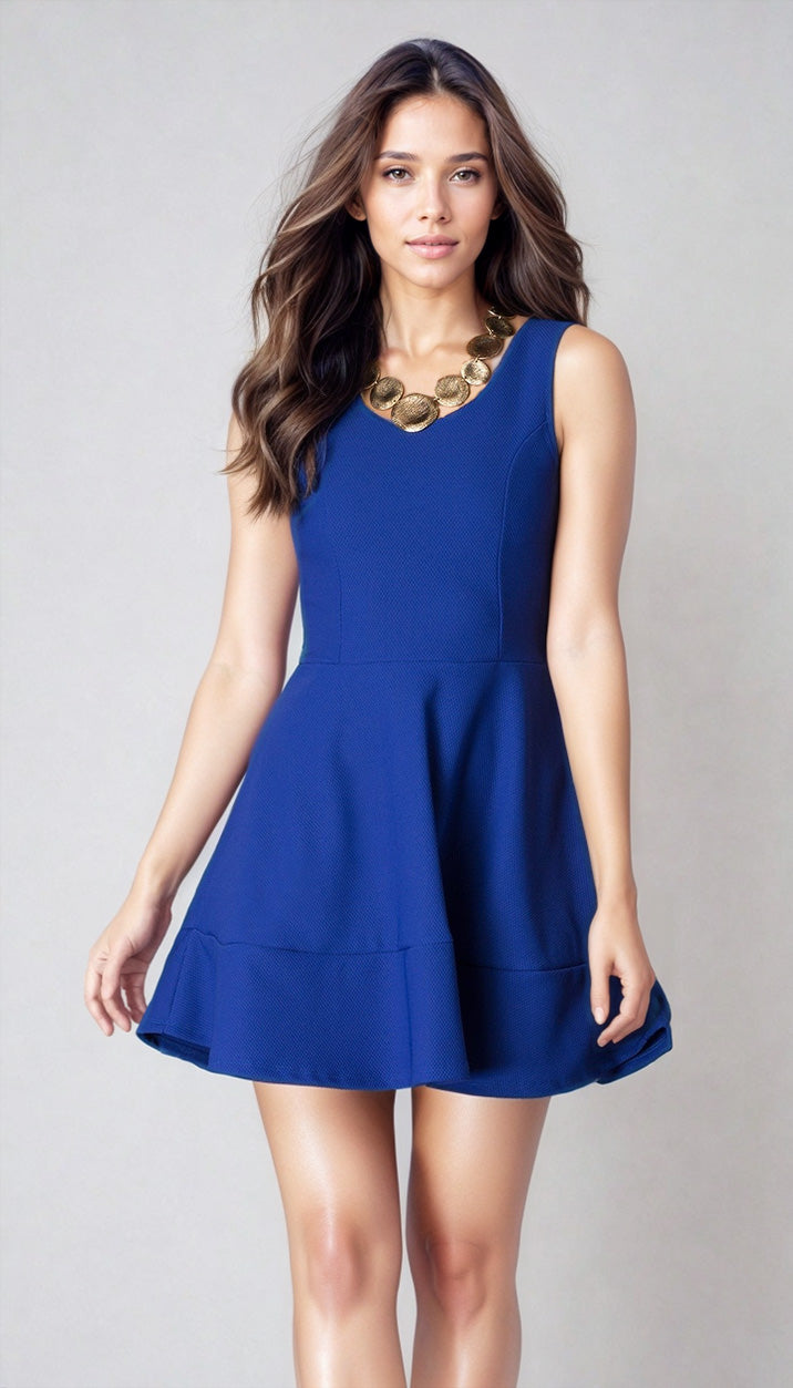 A woman models the Cheryl Creations Short Simple Homecoming Dress 2399—a sleeveless royal blue semi-formal dress—paired with a chunky gold necklace, standing against a plain light background.